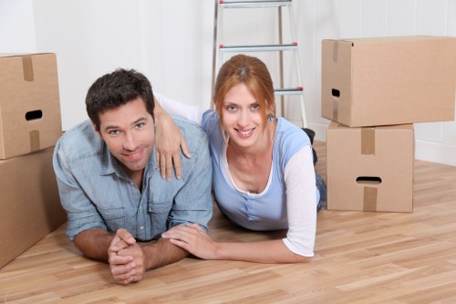Movers preparing bulky furniture for transport in a Chiswick property